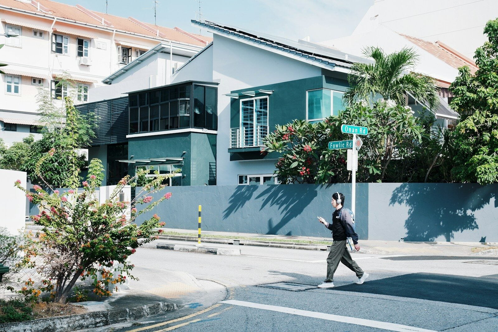 Person crossing street in front of modern house