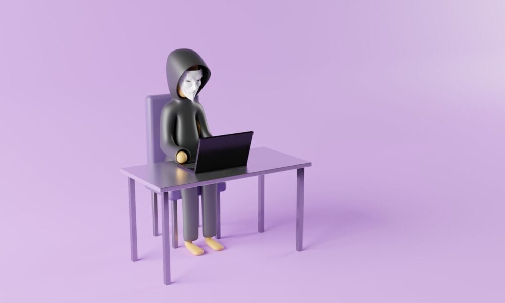 a person sitting at a desk with a laptop on it