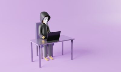 a person sitting at a desk with a laptop on it