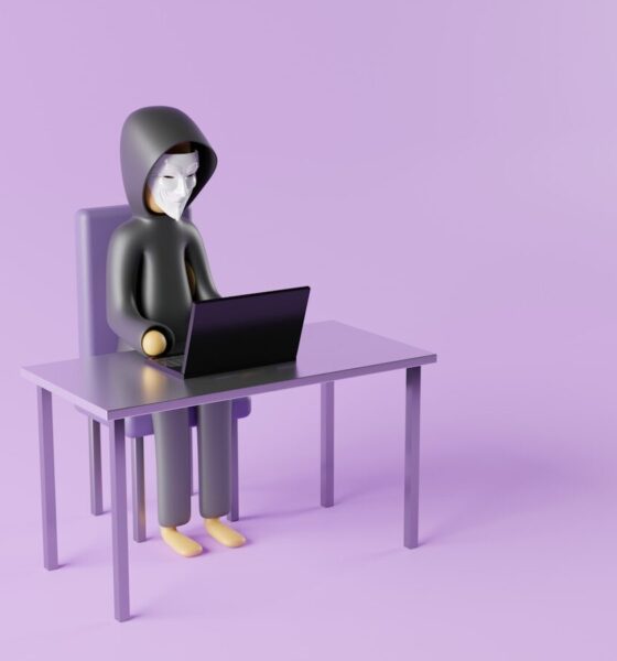 a person sitting at a desk with a laptop on it