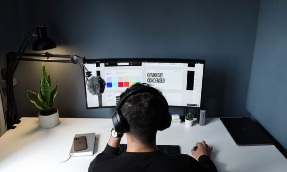 man in black shirt sitting in front of computer