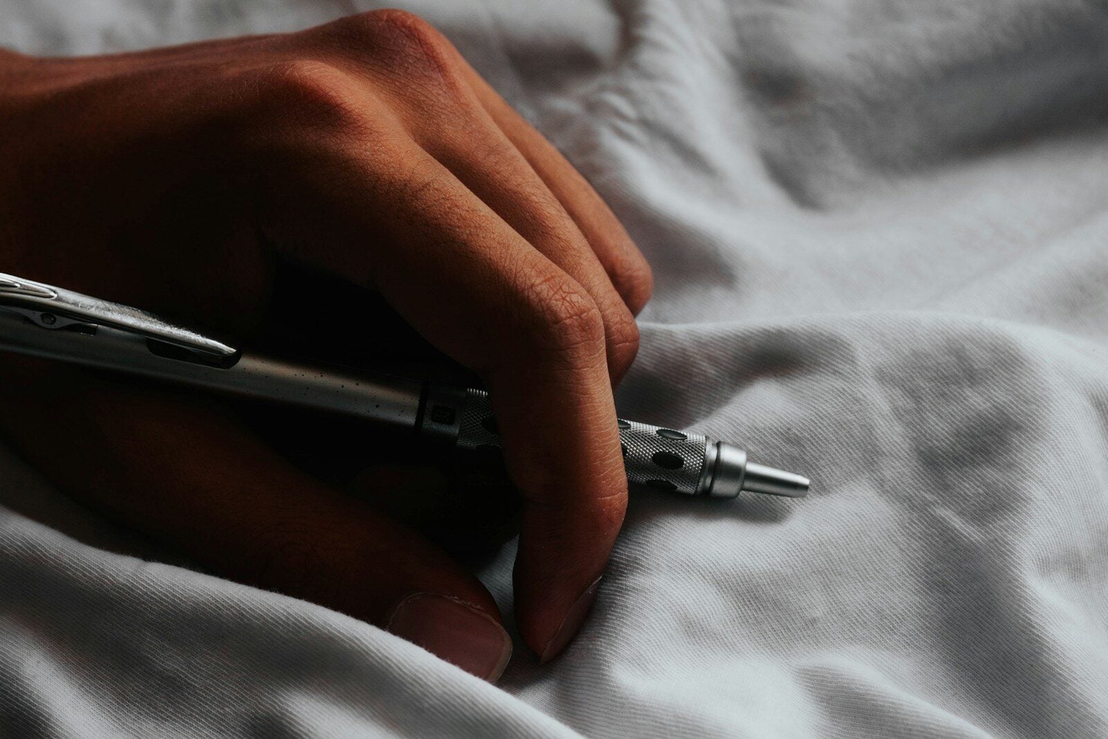 a person writing on a sheet with a pen
