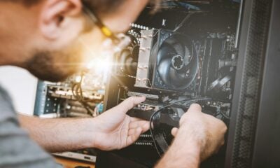 A person installing a graphics card into a computer case with a cooling fan