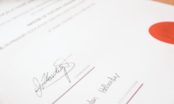 A university degree certificate with a red seal and two signatures