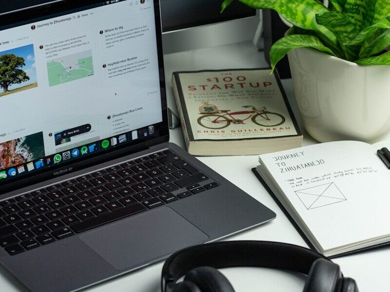 black and silver laptop computer beside black headphones