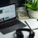 black and silver laptop computer beside black headphones