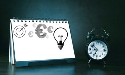 Desk calendar with business symbols and alarm clock