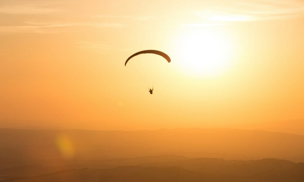 person parachuting during golden hour
