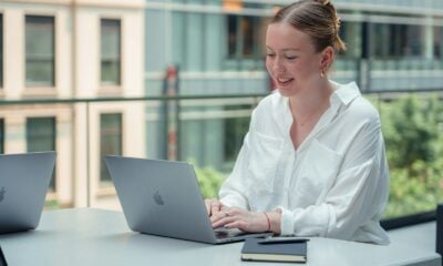 a woman sitting at a table using a laptop computer