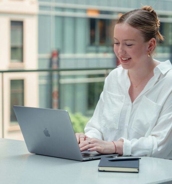 a woman sitting at a table using a laptop computer