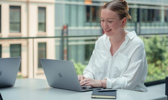 a woman sitting at a table using a laptop computer
