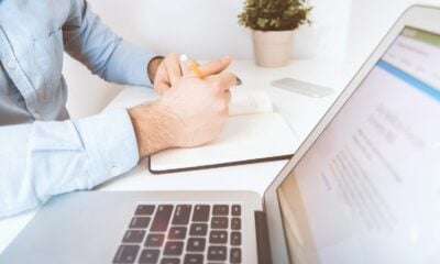 person writing on white notebook