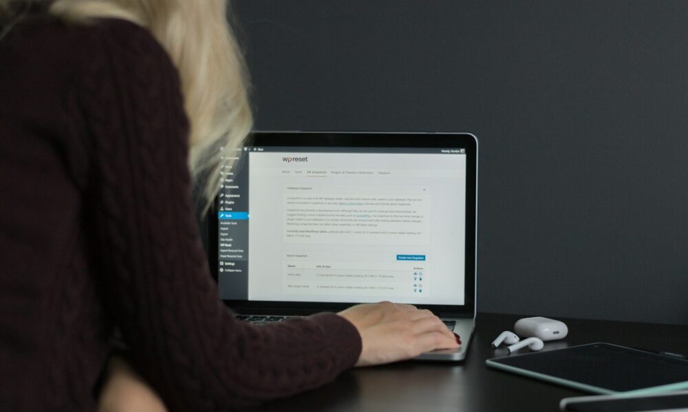 woman in black sweater using macbook pro
