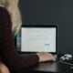 woman in black sweater using macbook pro