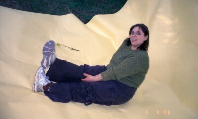 Smiling woman sitting on a large yellow inflatable structure