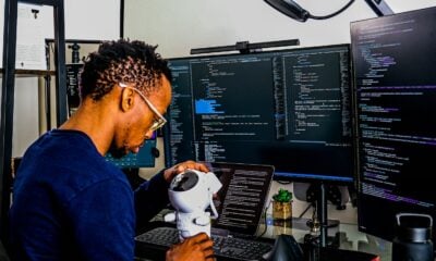 a man is looking through a microscope at a computer