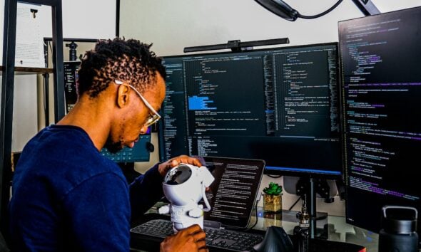 a man is looking through a microscope at a computer
