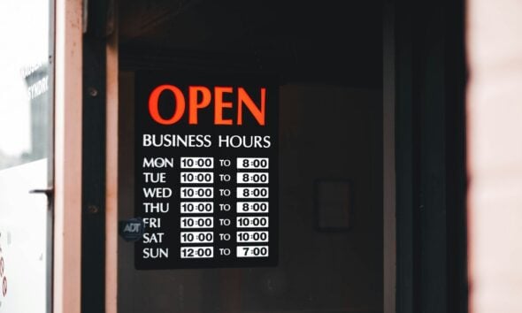 a sign on a door that says open business hours