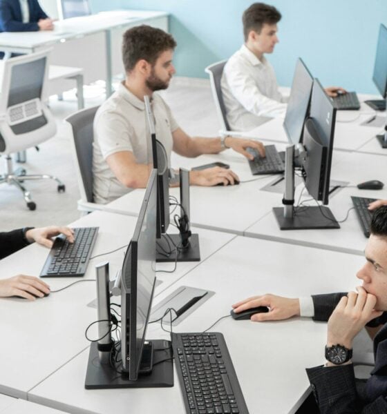 a group of people sitting at a table with computers