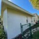 white concrete house with green metal fence