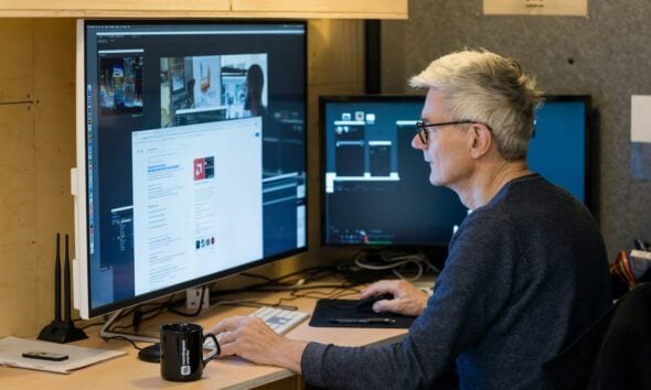 a man sitting in front of a computer monitor