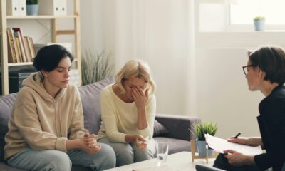 two women sitting on a couch talking to each other