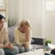 two women sitting on a couch talking to each other