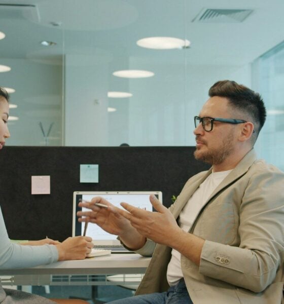 Two colleagues discussing work in a modern office