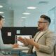 Two colleagues discussing work in a modern office