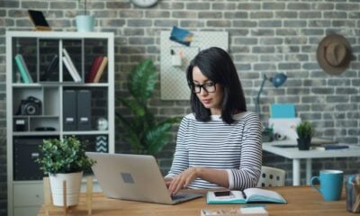 a woman sitting at a table using a laptop computer