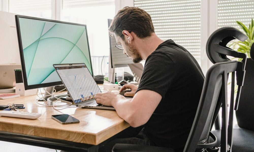 a man sitting at a desk working on a computer