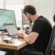 a man sitting at a desk working on a computer