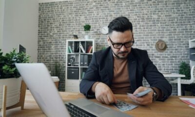 a man sitting at a table in front of a laptop