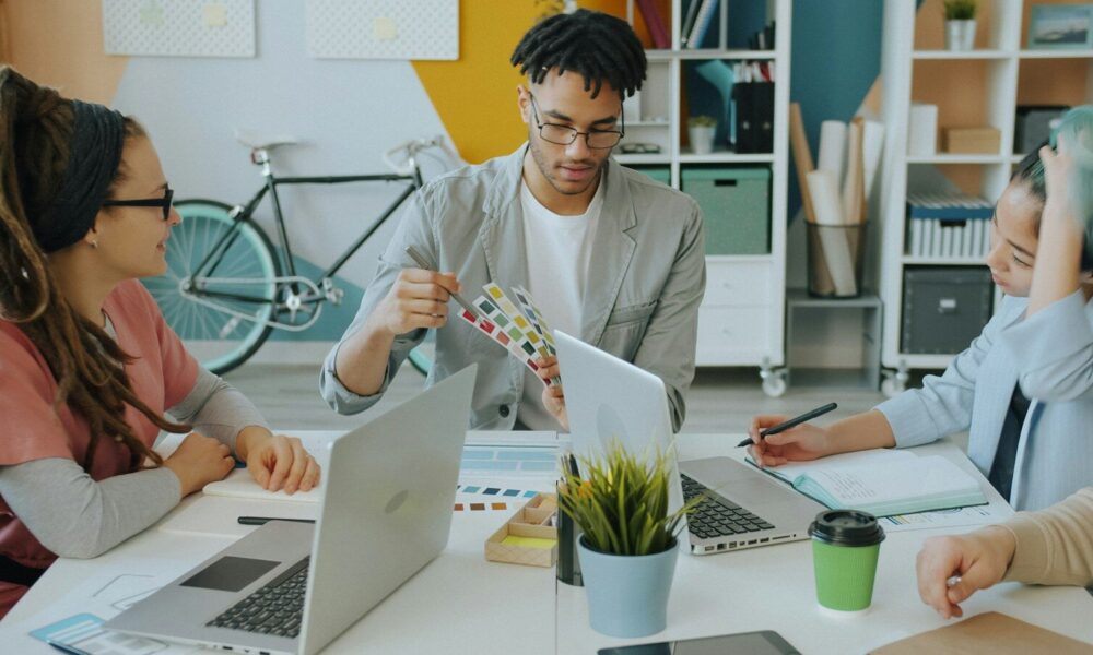 A group of people working together at a desk in a creative workspace