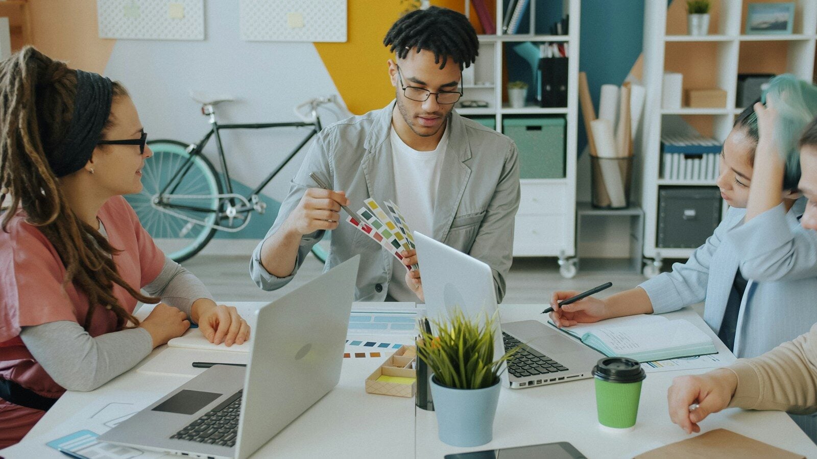 A group of people working together at a desk in a creative workspace
