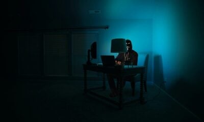 a person sitting at a desk in a dark room