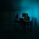 a person sitting at a desk in a dark room