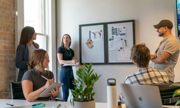 A group of people in a sunlit office during a collaborative workspace meeting