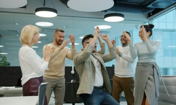 Diverse group of colleagues celebrating success in office