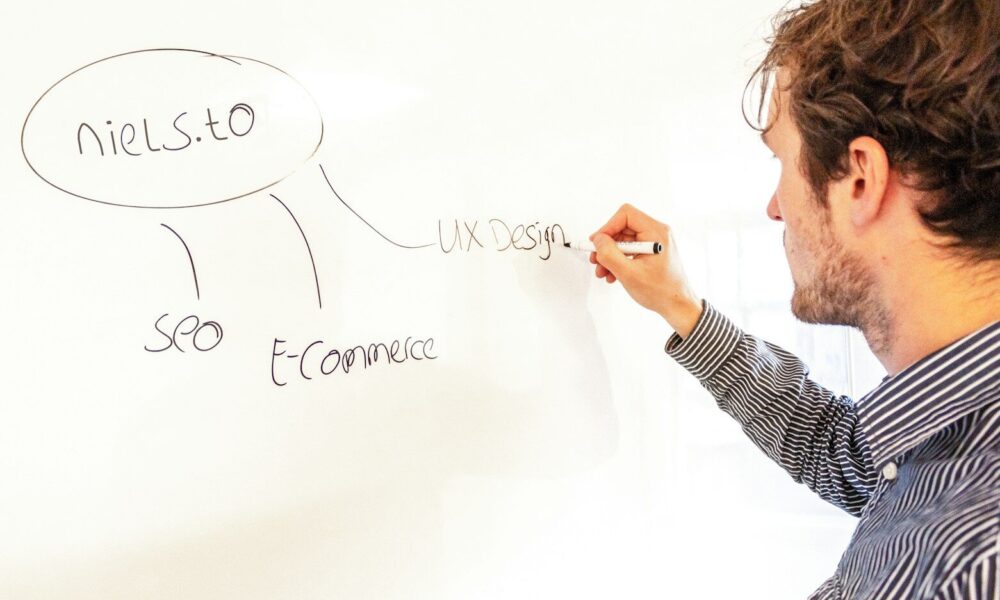a man writing on a whiteboard