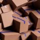A large pile of brown cardboard boxes with blue tape