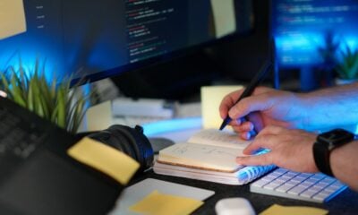 A person codes while taking notes