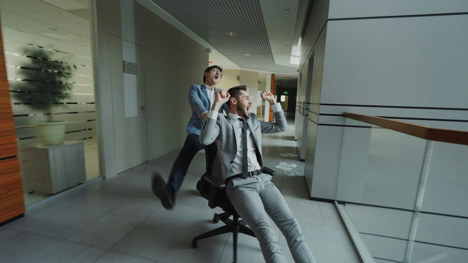 Two businessmen having fun in office hallway