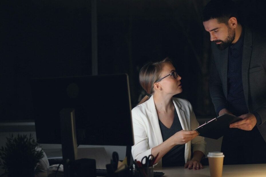Two colleagues working late in a dimly lit office