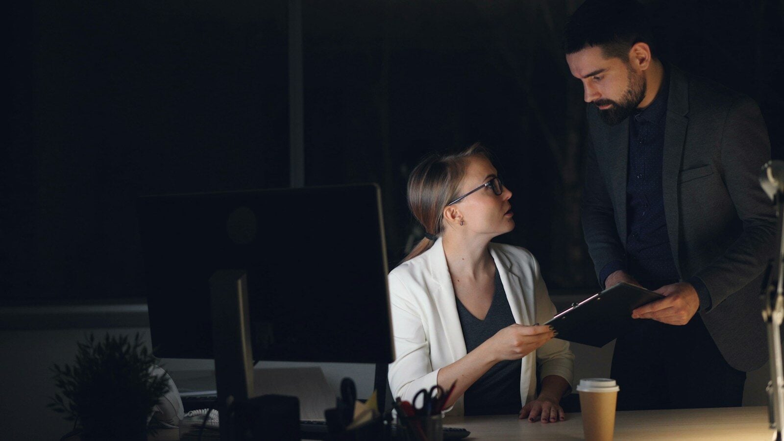 Two colleagues working late in a dimly lit office