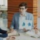 Man presenting charts to colleagues in a meeting