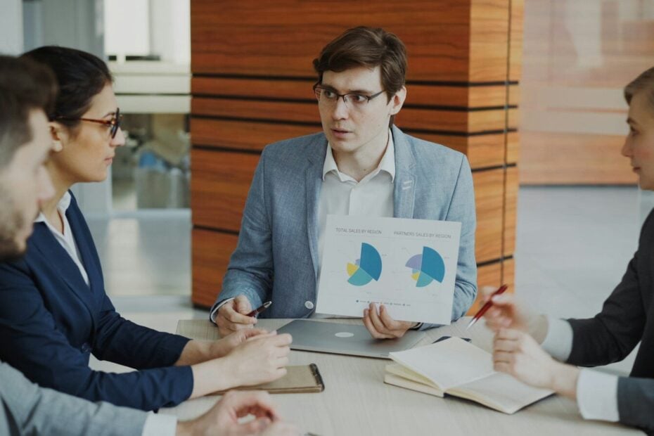 Man presenting charts to colleagues in a meeting