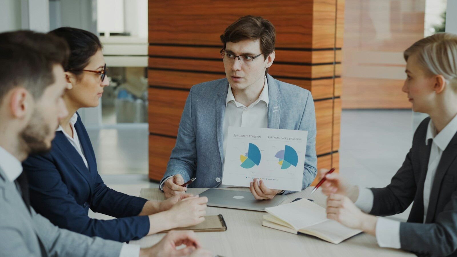 Man presenting charts to colleagues in a meeting
