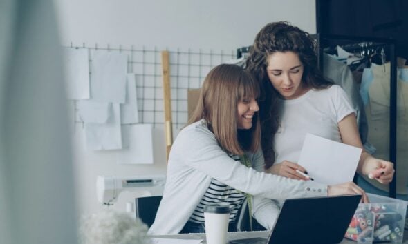 Two women are looking over papers