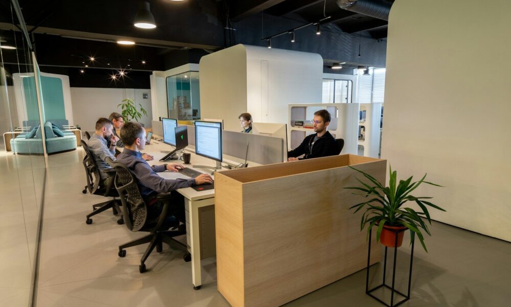 a group of people sitting at desks in an office
